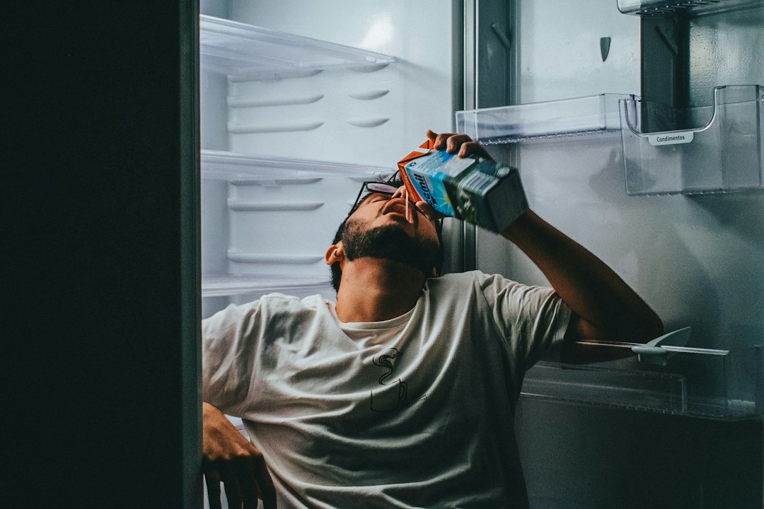 Man checking fridge storage to reduce food waste at home