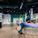Visitor comparing gallery membership prices at a ticket desk