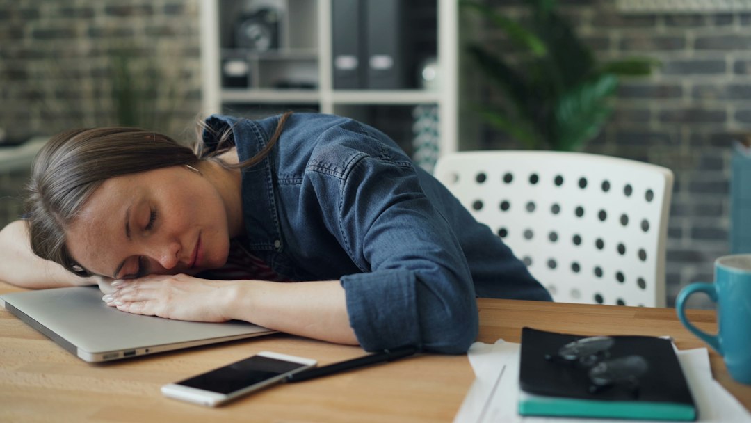 Office worker showing signs of mid-career burnout at her desk
